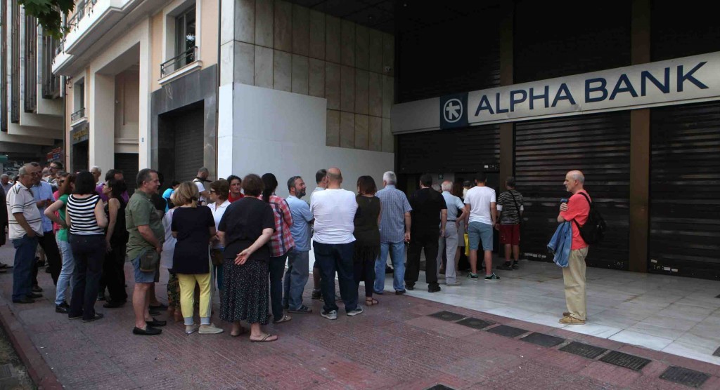 ATHENS, GREECE - JUNE 28: People wait in a queue in front of a bank's ATM to withdraw their cash in Athens, Greece on June 28, 2015. Greeks are anxious about whether the European Central Bank will increase the emergency liquidity assistance, banks can draw on from the country's central bank or not. (Photo by Ayhan Mehmet/Anadolu Agency/Getty Images)