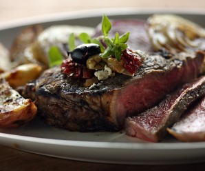 A marinade will add flavor and it will help tenderize the meat when making this grilled strip steak garnished with olives and feta cheese. (Kimberly P. Mitchell/Detroit Free Press/MCT)